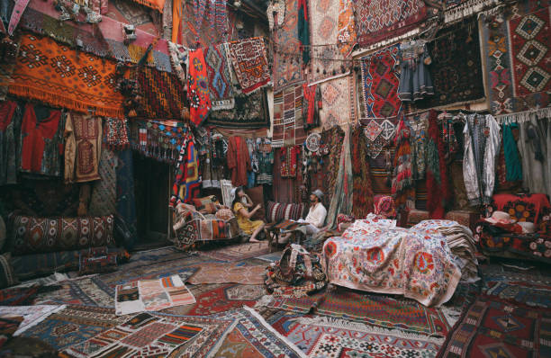 giovani turisti che si divertono nel tradizionale negozio di tappeti in cappadocia, turchia - bazaar foto e immagini stock