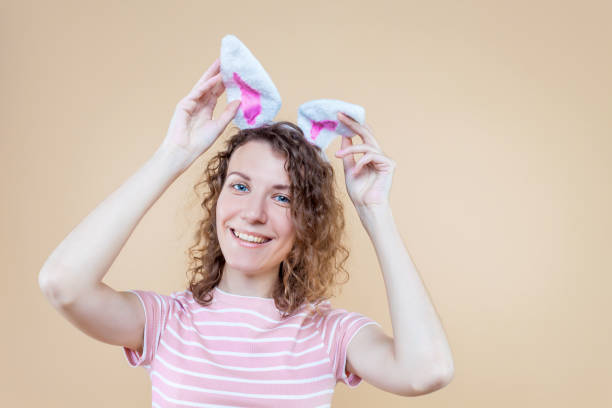 junge erwachsene frau auf isoliertem hintergrund - easter easter bunny fun humor stock-fotos und bilder