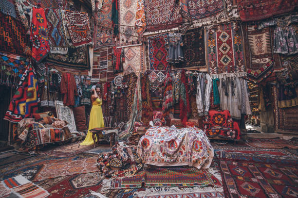 joven turista femenina disfrutando en la tienda de alfombras tradicional en capadocia, turquía - anticuario anticuado fotografías e imágenes de stock