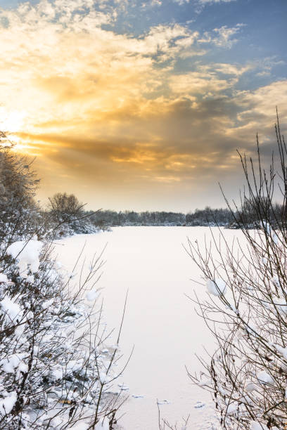 istock Sun set over frozen and snow covered lake. 1297091388
