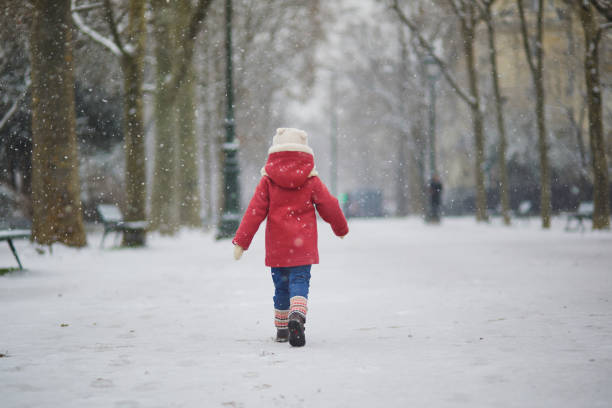 bambino felice che gioca con la neve - hat toddler little girls pink foto e immagini stock