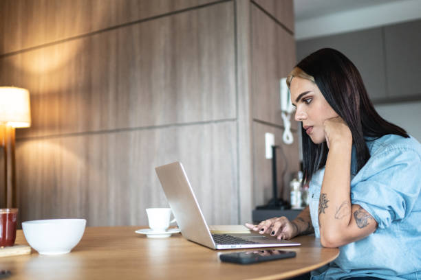 transgender-frau mit laptop oder arbeit von zu hause - transsexuell stock-fotos und bilder