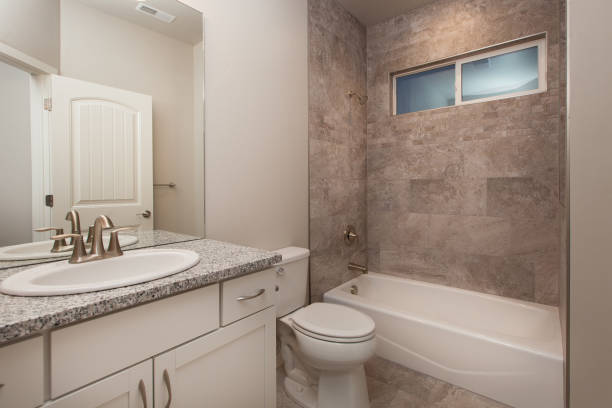 Modern Guest Bathroom White Cabinets, Grey Granite Countertops, White Walls, Tile Shower stock photo