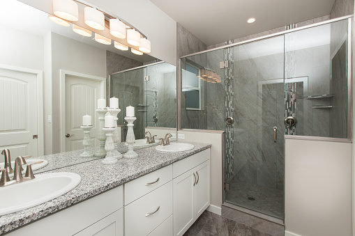 Moderno baño principal con gabinetes blancos con encimera de granito gris con lista de bienes raíces interiores walk in shower home photo