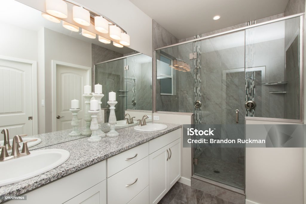 Modern Master Bathroom with White Cabinets with Grey Granite Countertop with Walk in Shower Home Interior Real Estate Listing New modern master bathroom with off grey granite counter tops and grey cabinets Bathroom Stock Photo