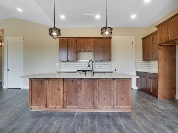 Modern Light and Bright Kitchen Dark Wood Floors with Red Brown Cabinets stock photo