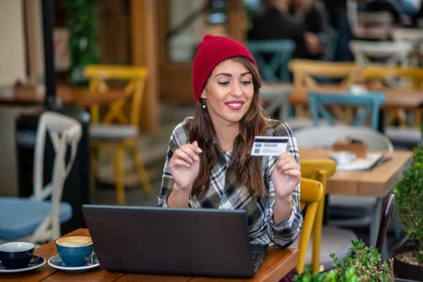 istock Lady in red knit hat paying online. 1297100036