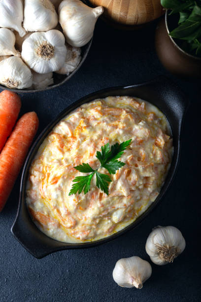 istock Carrot tarator in ceramic bowl with vegetable on dark background. Fresh carrot salad with garlic yogurt in bowl. 1297101092