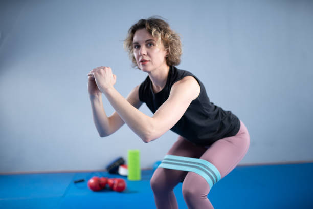Legs woman barefoot doing pilates exercise with elastic fabric resistance band. Resistance Bands for butt and Legs, Exercise bands working out, stretching, physical therapy. Elastic bands for fitness. piernas mujer descalza haciendo ejercicio pilates con banda de resistencia de tela elástica. bandas de resistencia para el culo y las piernas, bandas de ejercicio que hacen ejercicio, estiramiento, fisioterapia. bandas elásticas para el fitness