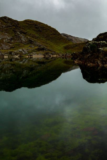 istock Rocky mountain reflecting on a lake, cloudy day 1297101468