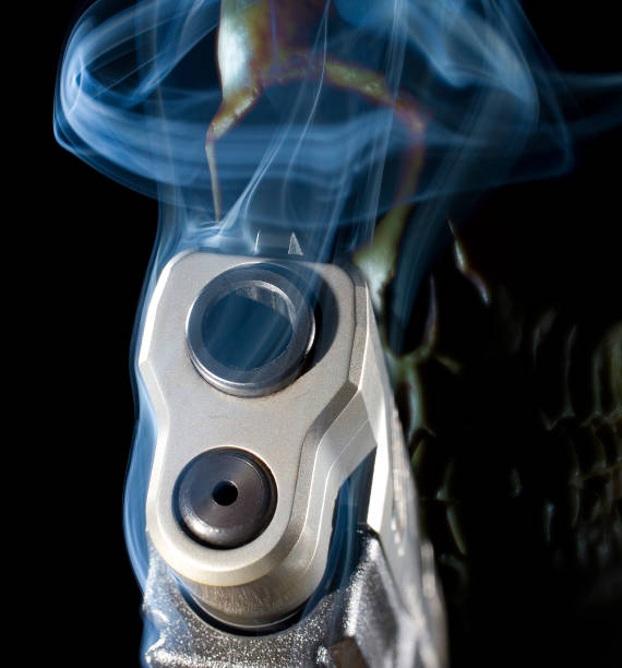 istock Smoking semi-auto pistol with a skull behind that represents a ghost gun 1297101524