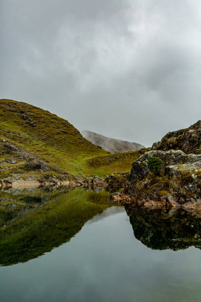 istock Rocky mountain reflecting on a lake, cloudy day 1297101734