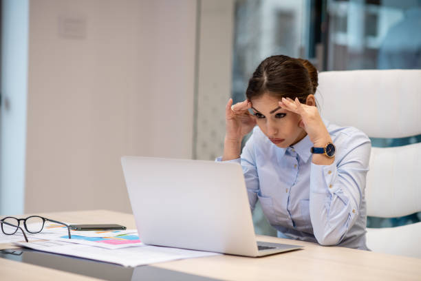 istock Businesswoman focused on work, sitting, holding forehead, having headache. 1297101755