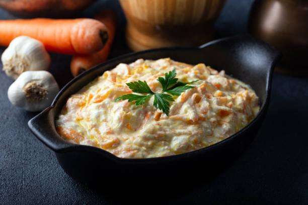 tarator de carotte dans le bol en céramique avec le légume sur le fond foncé. salade fraîche de carotte avec le yaourt à l’ail dans le bol. - orange sauce photos et images de collection