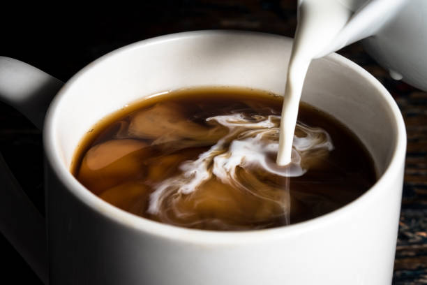 Pouring Creamer into a Cup of Coffee stock photo