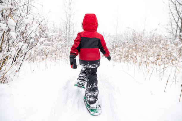 Little Boy Snowshoeing Outdoors in Winter During Snowstorm