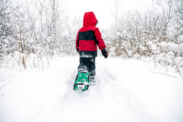 istock Little Boy Snowshoeing Outdoors in Winter During Snowstorm 1297104174