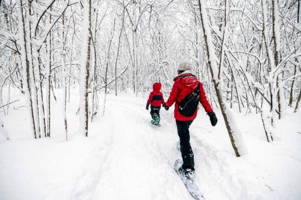 matka i syn snowshoeing na zewnątrz w zimie podczas śnieżycy - snowshoeing snowshoe child winter zdjęcia i obrazy z banku zdjęć