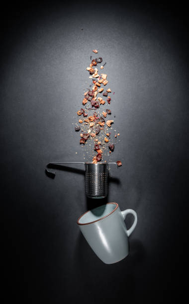 Flat lay composition of fruit tea cup and infuser - strainer. Flat lay isolated on gray black background stock photo