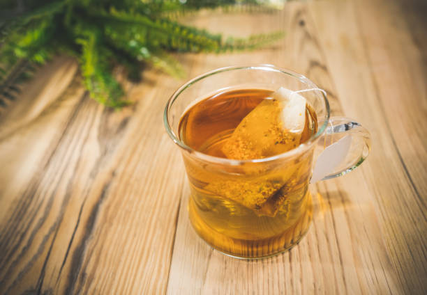 istock Teacup with bag and herbal leaves on wooden table, selective focus. 1297106321
