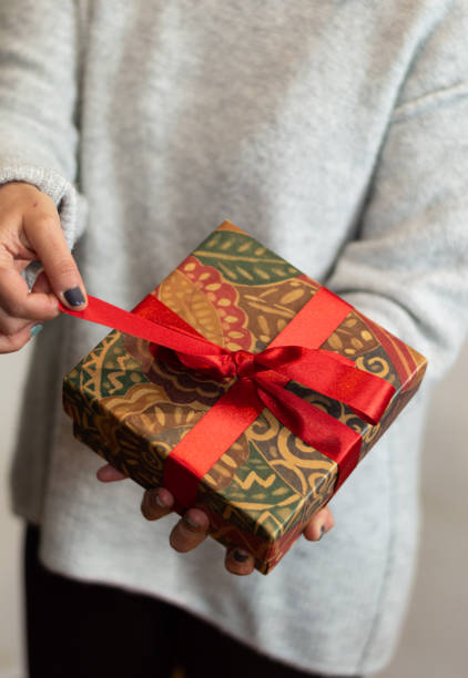 istock hands of a woman holding a gift box with a red bow. celebration concept 1297108793