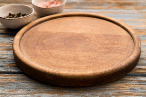 Round wooden pizza board with ingredients