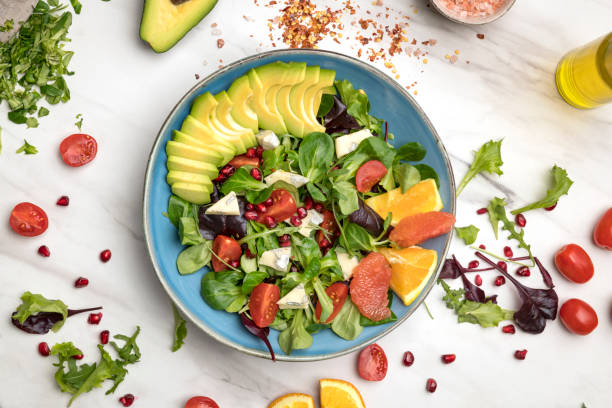 ensalada de dieta vegetal saludable en un plato sobre un fondo oscuro de madera. - freshness ingredient bowl food fotografías e imágenes de stock