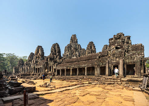 Angkor, Cambodia - January 22, 2020: The Bayon a richly decorated Khmer temple at Angkor in Cambodia. Built in the late 12th or early 13th century as the state temple of the Mahayana Hindu King Jayavarman VII. The Bayon's most distinctive feature is the multitude of serene and smiling stone faces on the many towers.