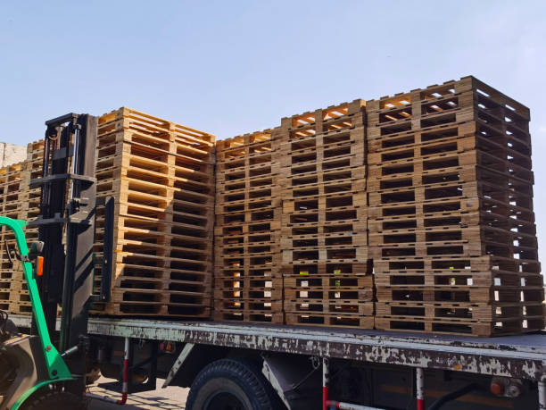 istock Worker driving forklift to loading and unloading wooden pallets from truck to warehouse cargo storage, shipment in logistics and transportation industrial, wood pallets stack 1297117145