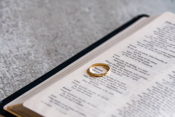 istock Wedding band on open Bible 1297118186