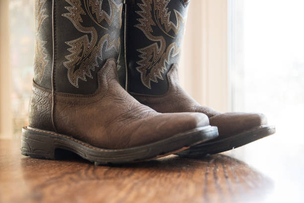 istock Brown Cowboy Boots on Wood Floor 1297118195