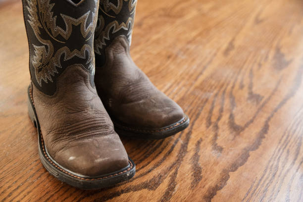 istock Brown Cowboy Boots on Wood Floor 1297118208
