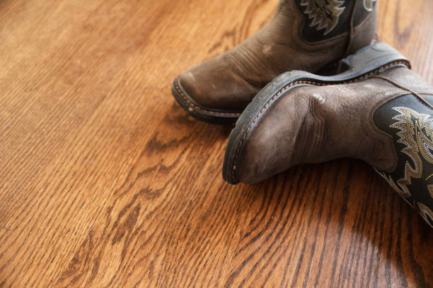 istock Brown Cowboy Boots on Wood Floor 1297118218