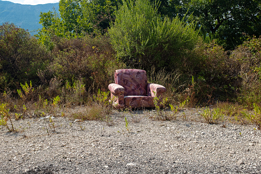 Tzoumerka, Epirus, Greece - August 23, 2019: Abandoned armchair under the sun