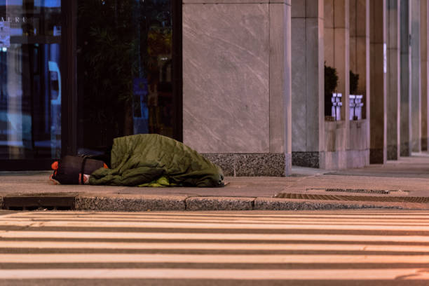 istock Homeless person sleeping on the sidewalk 1297123910