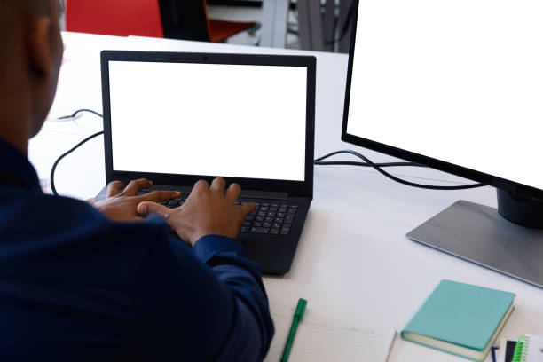 istock Mxed race businessman sitting using laptop and computer in a modern office 1297123983