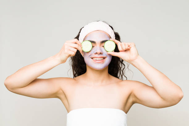 istock Beauty model is putting cucumber slices in her face 1297125016