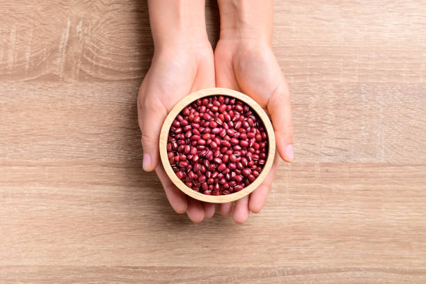 istock Azuki beans or red mung beans in a bowl holding by hand 1297125910