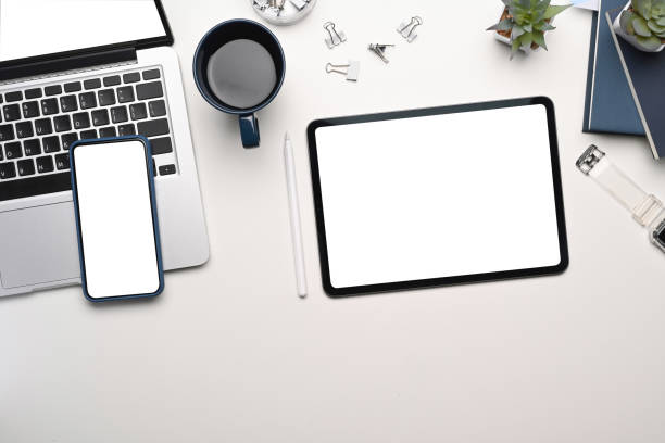 istock Top view of multiple electronic devices. Digital tablet, smart phone and laptop with white empty screen for advertise text. 1297128193