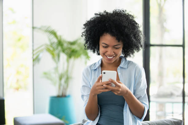 istock Smiling young woman text messaging on smartphone 1297130531
