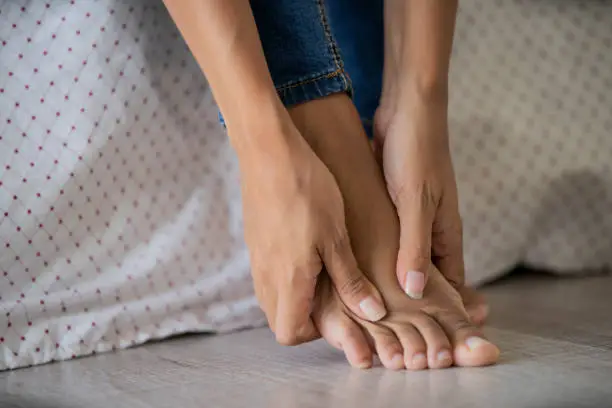 Photo of Low section of young woman massaging her foot