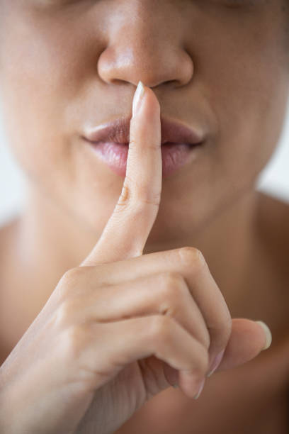 istock Woman with her index on her lips as silence symbol 1297131290