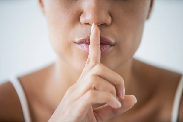istock Woman with her index on her lips as silence symbol 1297131341
