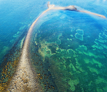 An aerial view of a narrow shoal at low tide on the Atlantic coast.