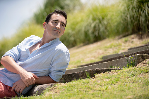 Thoughtful man leaning while sitting in garden