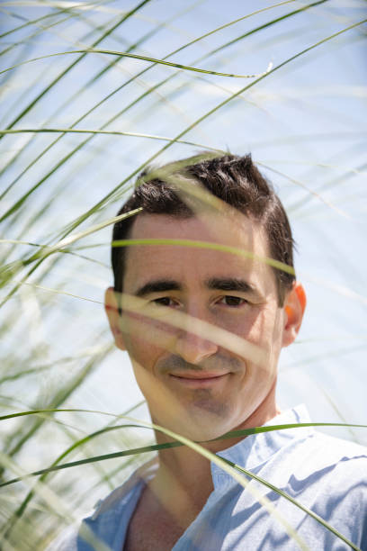 istock Portrait of man looking through some grass 1297132111