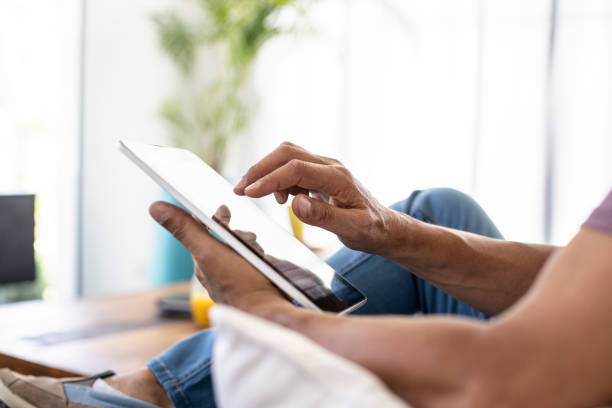 istock Low section of mature man using digital tablet at home 1297132331