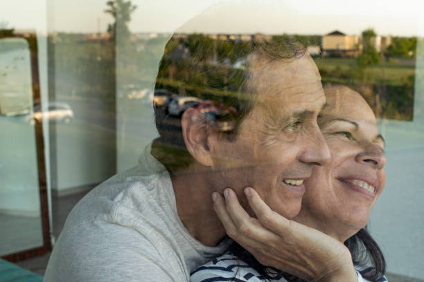 istock Smiling mature couple looking through window 1297133329