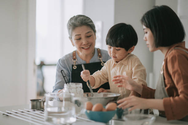 asiatische chinesische mehrgenerationenfamilie bereitet essen mit mehlbacken an küchentheke zusammen - grandmother cooking baking family stock-fotos und bilder