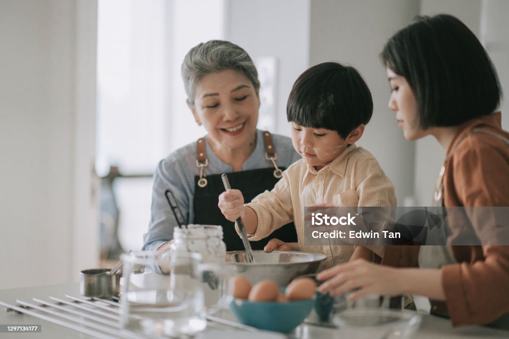 asian chinese multi generation family preparing food with flour baking at kitchen counter together Multi-Generation Family Stock Photo
